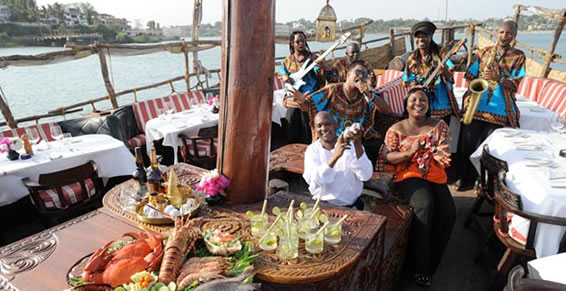 Guests enjoying a seafood dinner and live music aboard the Tamarind dhow
